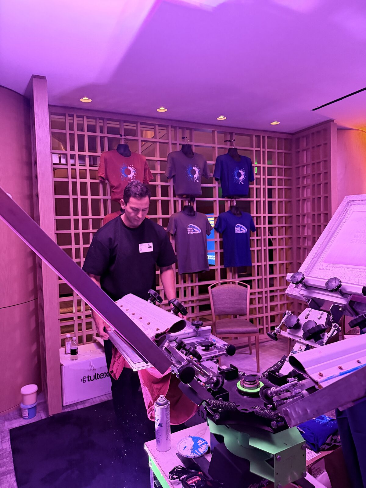 Loading a shirt onto the press at a live printing bar