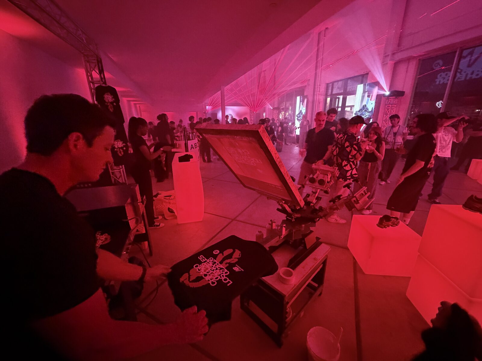 Guest holding up a freshly printed custom shirt at a party shirt bar