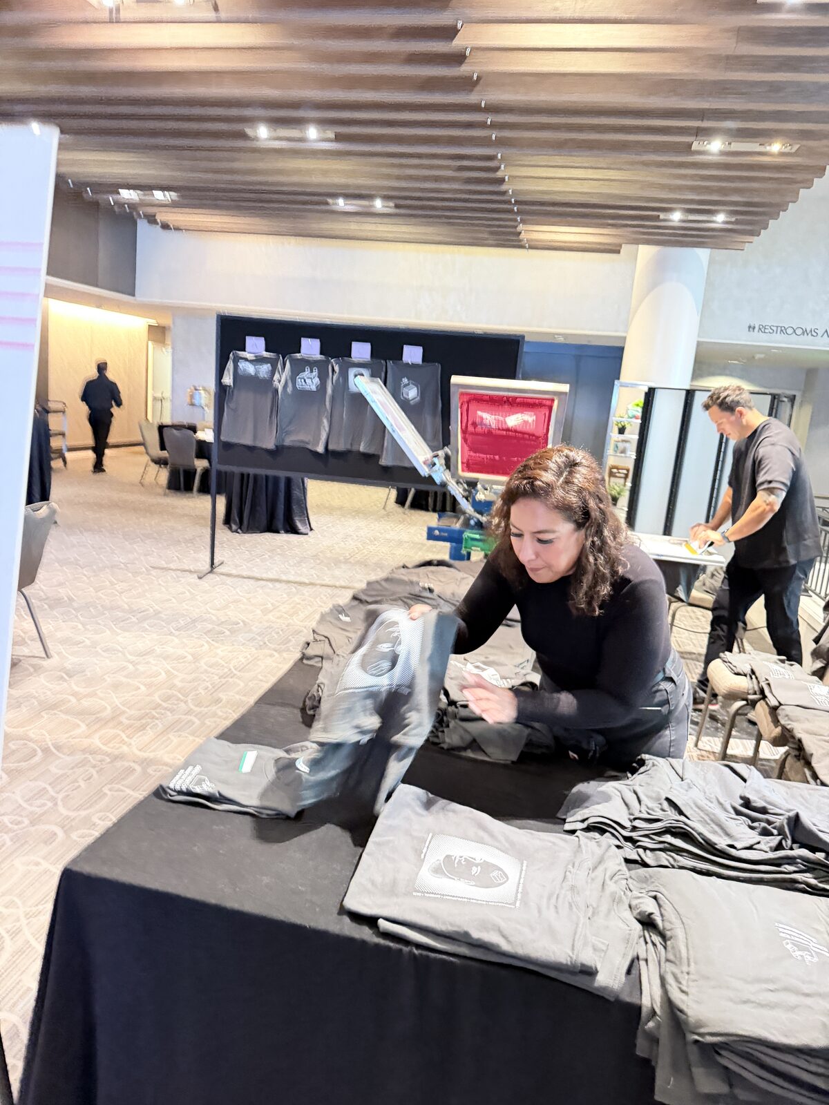 Crew folding freshly printed custom shirts for guests