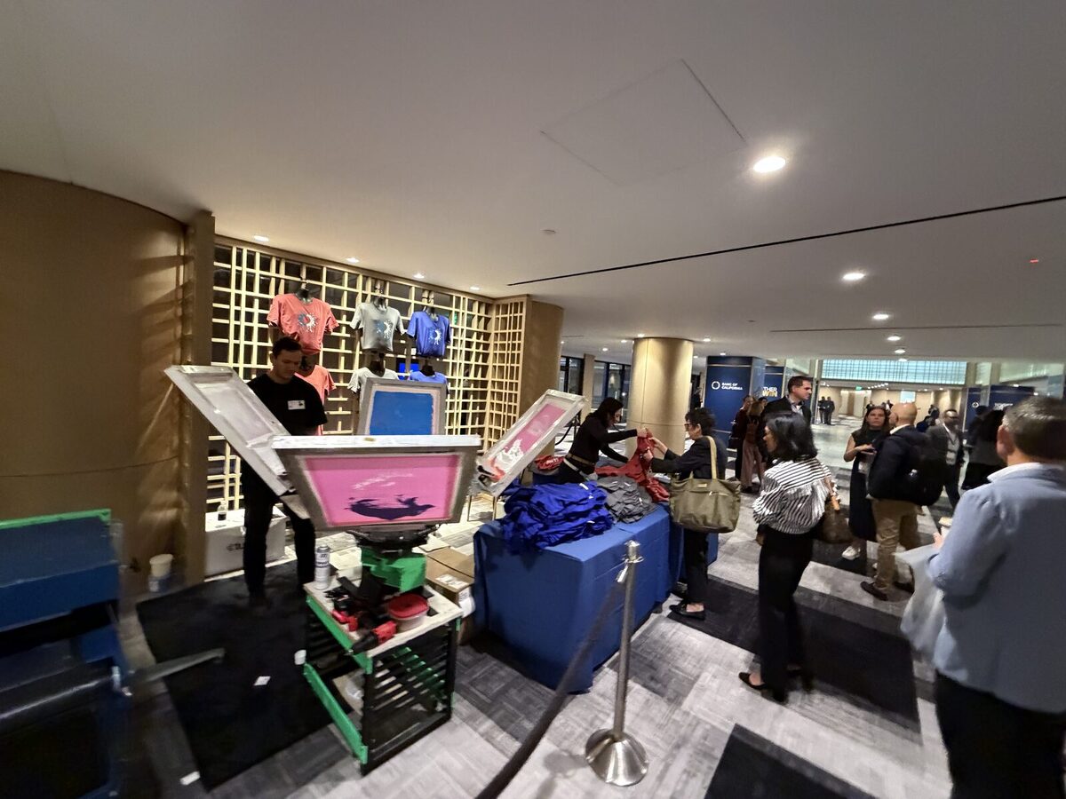 Crowd gathered around a live shirt printing bar at an event